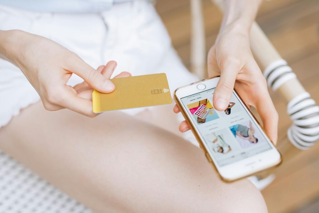 Close-up of a woman holding a smartphone and credit card for online shopping. Modern e-commerce concept.